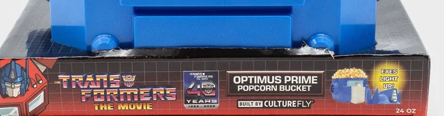 The printed band on the popcorn bucket packaging, reading The Transformers The Movie, a 40 Years 1986 to 2026 badge, Optimus Prime Popcorn Bucket, Built by CultureFly, Eyes Light Up, 24 OZ