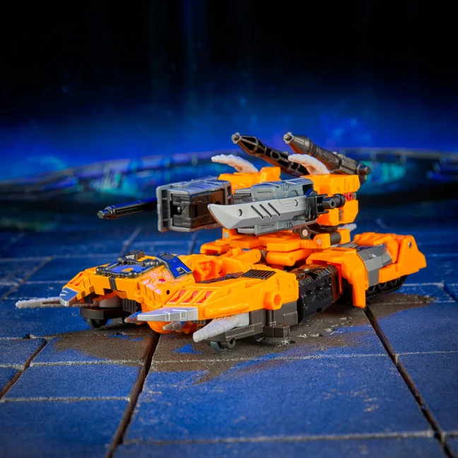 Herald of Unicron in tank mode, a low orange and grey vehicle with the horned armour folded flat along the hull.