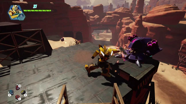 Bumblebee in robot mode striking a purple Decepticon drone on a metal platform above a red rock canyon, with a health bar and item counters from the game's own interface at the edges of the screen