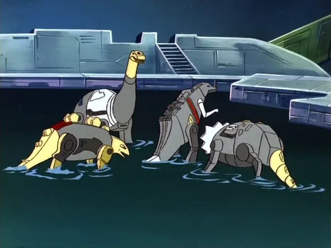 Four Dinobots stand in a pond of water in front of a Cybertronian dock, their heads lowered toward the surface, with a staircase and a green and grey hull behind them.