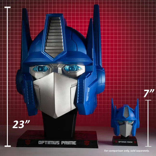 McFarlane's 23 inch Optimus Prime head replica photographed beside the 7 inch 1:3 scale bust, with height callouts reading 23 inches and 7 inches.