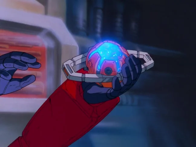 A red robotic arm and dark blue hand holding the Matrix of Leadership, its silver casing split open around a glowing blue core, with a second blue hand reaching in from the left.