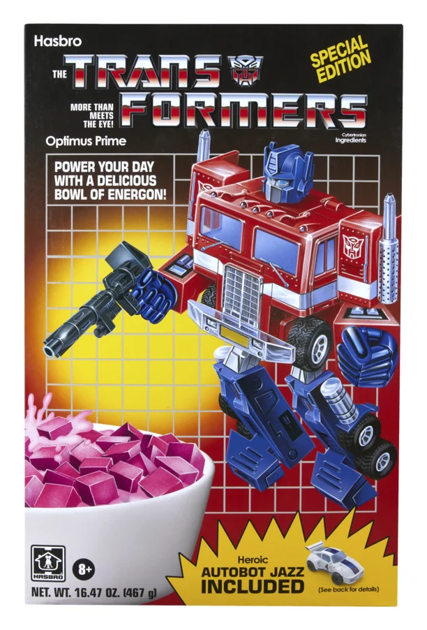 Front of the SDCC 2026 exclusive Transformers cereal box packaging, showing G1 style Optimus Prime box art over a bowl of pink Energon cereal, with a Special Edition flash and an Autobot Jazz Included banner in the corner