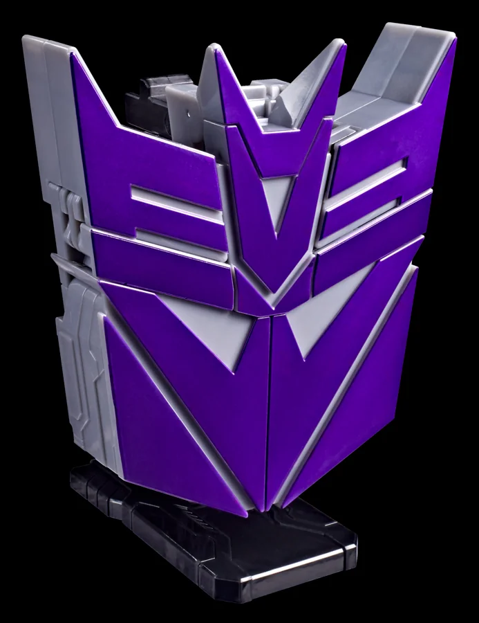 Transformers Icons Megatron converted into its Decepticons faction symbol display mode, a purple and silver logo standing upright on a black display stand
